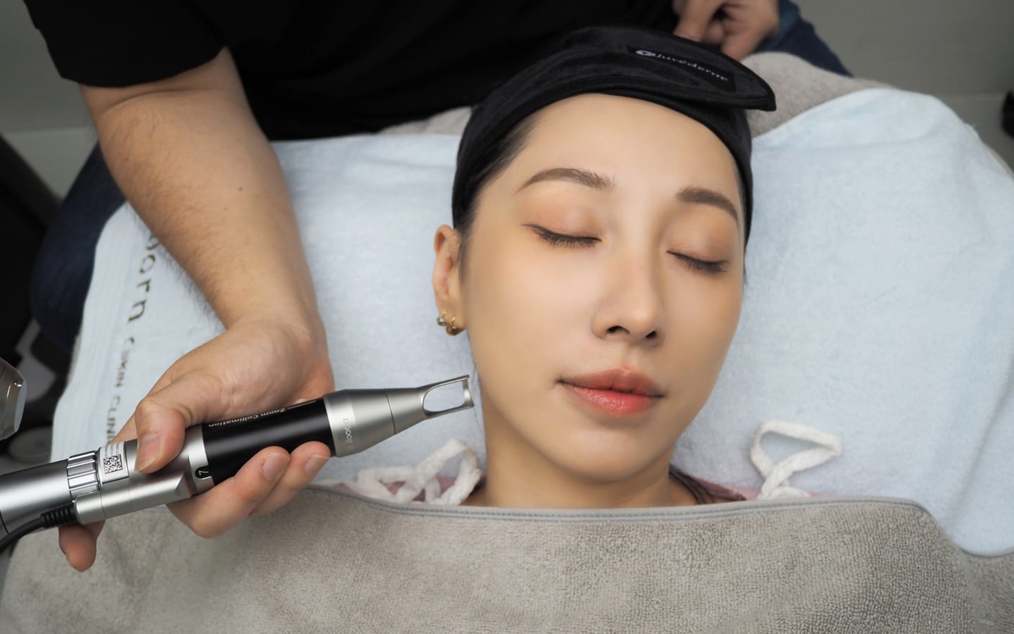 Doctor performing a laser treatment on a patient's face at Reborn Skin Clinic