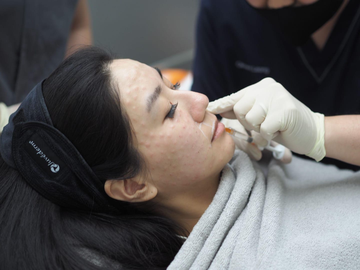Doctor administering a skin booster injection to a patient's face at Reborn Skin Clinic